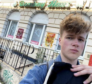 Junger Mann mit einem schwarzen ucm Beutel vor einem Restaurant