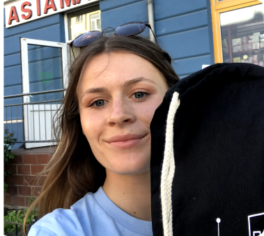 Junge Frau mit einem schwarzen Beutel vor einem Asia Imbiss